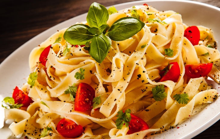 Nudeln mit Tomaten auf Holztisch